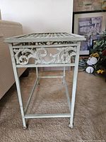 Side view showing scrollwork apron, tubular legs, stretcher base, distressed paint