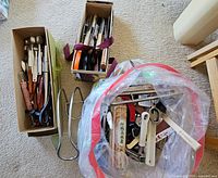 Three containers of loose metal and plastic utensils and flatware