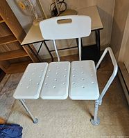 Front view of wide bath seat showing seat panels, legs and side arm