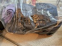 Clear bag with folded denim and other pants visible