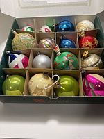 Box showing 16 assorted glass ball ornaments in compartments