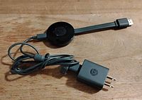 Front view of Chromecast puck with HDMI connector and bundled power adapter