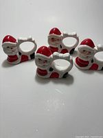 Front view of four ceramic Santa napkin rings