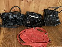 All four handbags displayed together on wooden surface