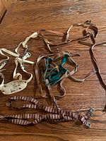 Overview of three harnesses and suspenders on table