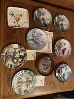 Front view of all nine decorative plates laid out on tabletop