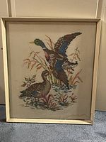Full view of duck cross-stitch in light frame