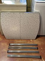 Tabletop folded, four chrome legs visible