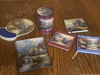 Group shot showing plate front, tin, two books, mousepad