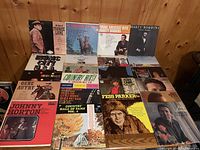 Sixteen country & western LP covers on tabletop, artists include Frankie Laine, Marty Robbins, Gene Autry, Johnny Horton, Roger Miller, Fess Parker
