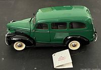 Left front and side view of the green/black die-cast 1946 Chevrolet Suburban with information card