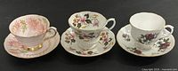 Three teacup and saucer sets displayed side by side
