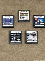 Five Nintendo DS cartridges laid out label side up
