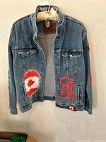 Front view of denim trucker jacket showing graphics and patches