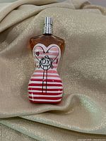 Front of the perfume bottle showing striped design and fill level