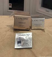 Two boxed 15 ml Lancôme skincare products and Génifique sample displayed together