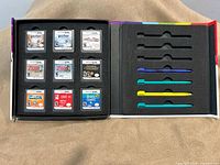 Open storage case showing nine cartridges and four styluses in foam slots