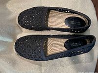 Top view of both espadrilles showing cutout design and interior label