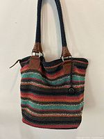 Front view of multicolor crochet hobo bag showing striped pattern, leather trim, braided strap