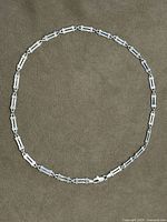 Full view of sterling silver bar-link necklace arranged in oval to show entire design