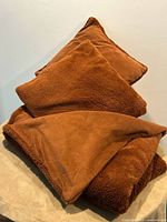 Throw and two pillows stacked together