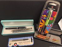 Overview of pens in boxes, Sheaffer refill, wood pen set, Sheaffer packaged pen