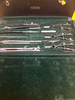 open case showing Dietzgen Constructo marking and six metal drafting instruments in green velvet liner
