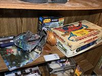 Shelf view with Star Wars puzzle box, Spider-Man board game, wooden puzzle, bagged toys visible