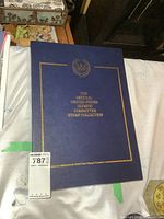 Front cover of blue binder with gold title and emblem