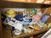 Shelf view showing variety of ceramic teapots and creamers