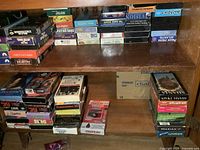 Two shelf view of numerous VHS tapes in cabinet