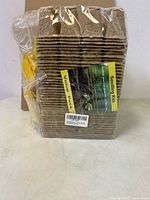 Front view of sealed stack of fiber seedling pots with label visible