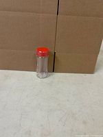 Single clear plastic jar with red lid shown upright for scale