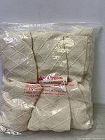 Front view of sealed package showing folded beige diamond-pattern seat covers