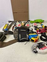 Entire lot on table showing tool belt, hammer, level, pliers, lanyards, rope grab