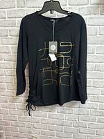 Front view of black long-sleeve top showing print and drawstring hem