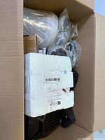 Box contents overview showing foam-wrapped item and black mounting plates