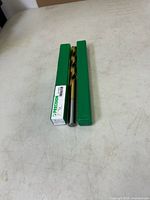 Drill bit in closed green plastic tube