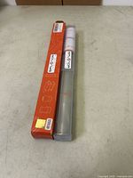 Ring mandrel in protective sleeve beside branded box