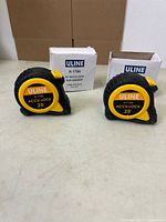 Front view of two Uline 25' tape measures with their boxes