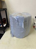 full view of large blue cleaning roll in plastic wrap