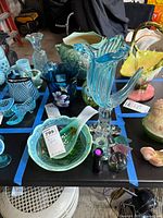 Overview of all art glass pieces on table within blue tape boundary