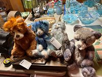 Group shot of four Charlie Bears in assorted colors on table