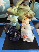 Four Fenton hand painted glass pig figurines, assorted colors