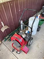 Full view of red MTD air sweeper showing handle, wheels and engine