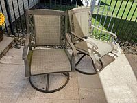 Both matching swivel patio chairs on patio surface