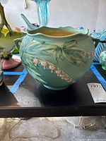 Front view of Roseville vase showing floral design and matte green glaze
