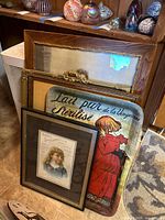 Front view showing French tin sign, Ayer's Sarsaparilla print, two stacked framed paintings and ornate frame