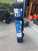 Carry bag containing blue Easy Shade 10x10 pop-up canopy with product labels visible