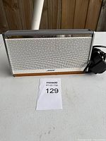 Front view of Bose SoundLink speaker showing grille and AC adapter